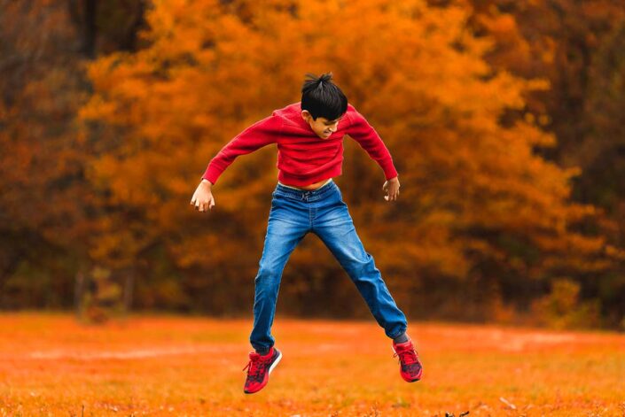 Naperville family photographer boy jump fall autumn